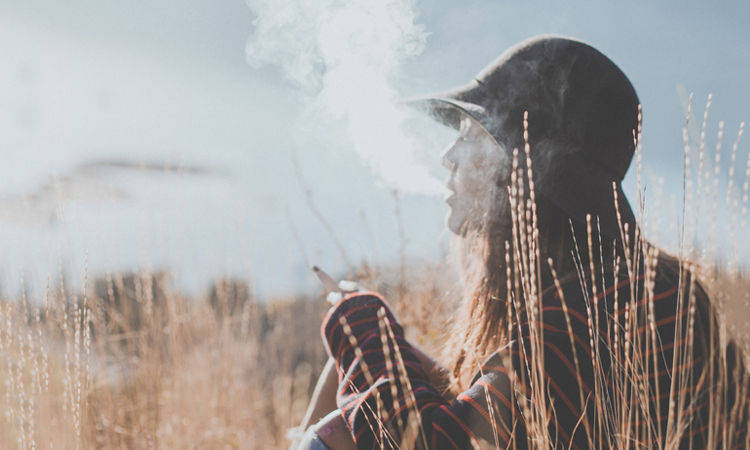 Woman smoking cannabis joint in mountains